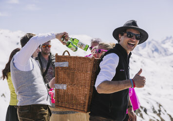 Ein Mann trägt einen Korb auf dem Rücken der mit Bier gefüllt ist.