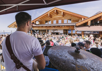 Ein Mann singt und spielt Gitarre vor einem Publikum.