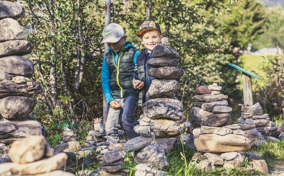 Zwei Jungs bauen einen Steinturm
