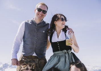 Ein Mann und eine Frau in Tracht trinken Bier.