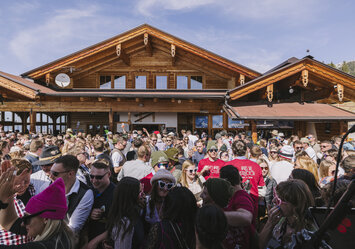 Ein Gruppe feiert vor einem Haus.