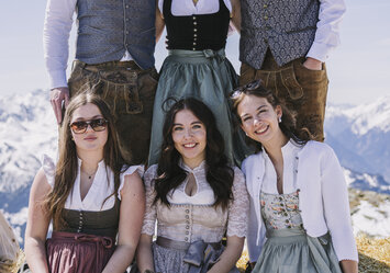 Zwei Männer und vier Frauen in Tracht posieren für ein Foto.