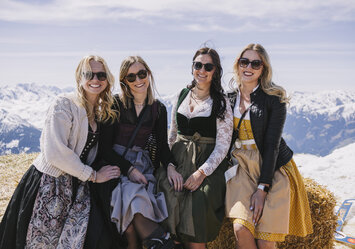 Vier Frauen in Dirndln posieren für ein Foto.