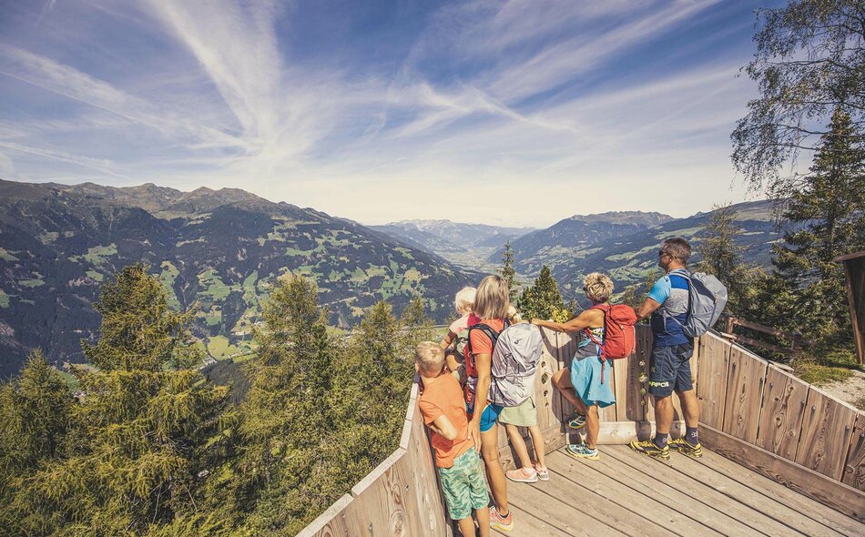 Eine Familie steht an einem Aussichtspunkt.