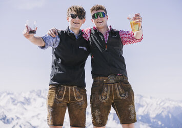 Zwei Jungs in Trachtenkleidung und Sonnenbrille posieren für ein Foto.