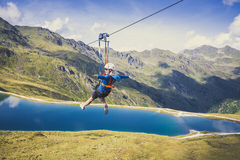 Eine Frau fährt mit einer Zipline über der traumhaften Natur