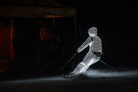 Ein Skifahrer ist von Kopf bis Fuß beleuchtet