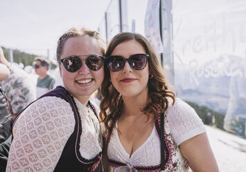 Zwei Frauen tragen Dirndl und Sonnenbrille.