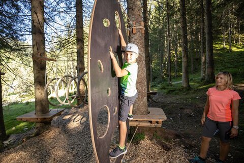 Eine Frau beobachtet einen Jungen beim Klettern