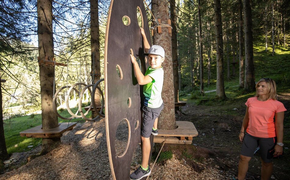 Eine Frau beobachtet einen Jungen beim Klettern