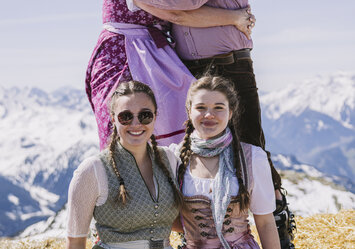 Drei Frauen und ein Mann in Tracht posieren für ein Foto.