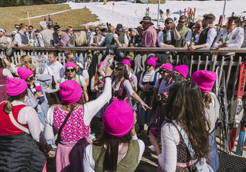 Frauen mit pinken Mützen feiern und trinken Bier.